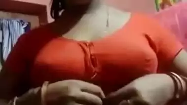 Aroused Desi wife slowly takes red top off to expose boobs for XXX fans